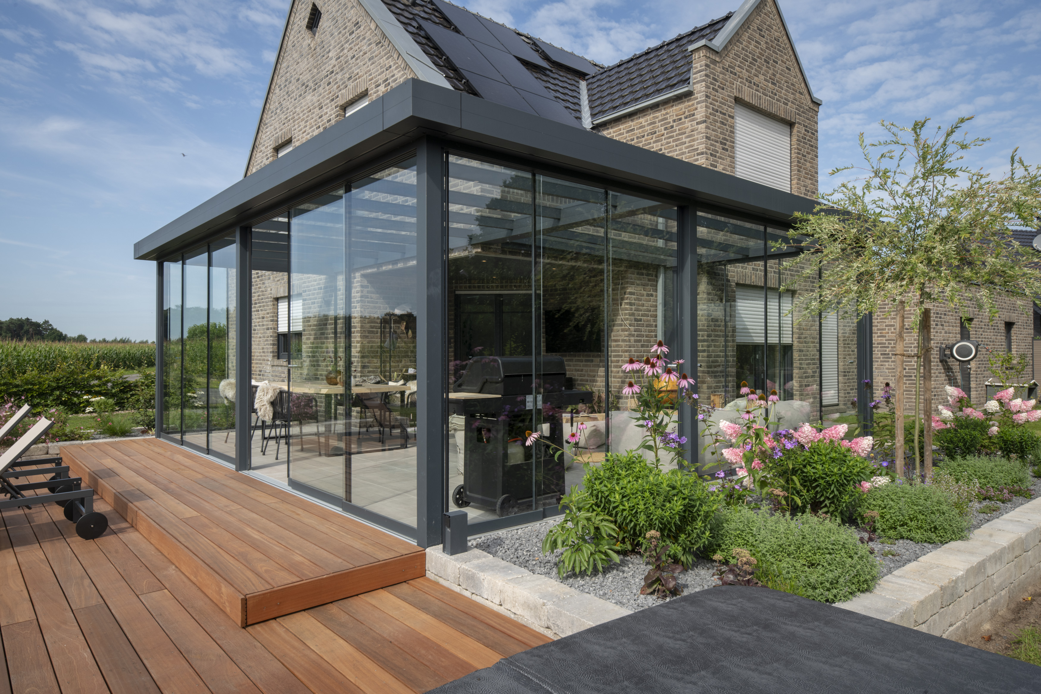 Moderner Anbau mit Glasfassade und Holzterrasse